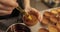 Close-up of the confectioner\\\'s hands smearing tartlets with a cooking brush.