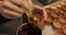 Close-up of the confectioner\\\'s hands smearing tartlets with a cooking brush.