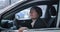 Close-up of confident adult Caucasian woman sitting on driver`s seat and closing door. Portrait of businesswoman in new
