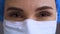 Close up of a confident female doctor face smiling and nodding approvingly. Surgeon or nurse in a mask looks straight