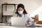 Close up confident female doctor wearing face mask using laptop