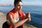 Close-up of confident and focused fitness woman looking at the sea, doing squats and workout on fresh air