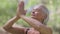 Close-up of confident slim fit retiree meditating in lotus pose closing eyes. Portrait of calm slim Caucasian yogi