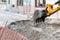 Close-up of a construction site excavator earth mover digging the street construction and reconstruction reparation