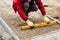 Close up of construction worker installing and laying pavement stones on terrace, road or sidewalk. Worker using pavement slabs an