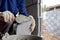 Close-up of construction workers using cement trowel on the brick to build walls.