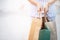 Close up of consumerism young woman holding hand many shopping bag in fashion boutique after buying presents while walking along t