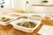 Close up of containers with ready healthy dinner with noodles, mussels and microgreens on the table.