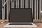 Close up of contemporary wooden designer office desktop with empty mock up laptop screen and other items. Decorative wall in the