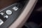 Close-up of control button open close the trunk door on the driver`s brown Leather Interior Door Handle in a new modern