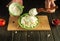 Close-up of a cook hands with a spoon adding sour cream to milk cheese on a kitchen black table while preparing diet food