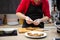 Close up of cook man in rubber gloves prepare snacks grilled sandwiches. Soft focus, background is kitchen in blur.