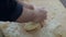 Close-up of a cook's hand. Flour is scattered on the table.