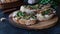 Close-up of a cook sprinkling fresh herbs bruschetta cream over cheeses