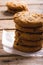 Close-up of cookies stacked on parchment paper at wooden table, copy space