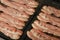 Close up cooking bacon slices on electric grill