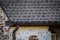 Close-up of copper guttering of brick house with screen and mounted red and green Christmas decortion lights