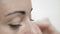 Close-Up Cosmetician Aligns Eyebrows to Beautiful Client