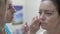 Close-Up Cosmetician Applies Special Remedy with Cotton Bud on Eyebrow of Beautiful Woman Before Tattooing