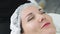 Close up cosmetologist cleans woman skin with wet cotton pads before face care procedure