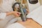 Close-up of cosmetologist doing massage with special vacuum apparatus on female belly