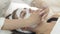 Close up cosmetologist hands rub in clay mask into girl face in beauty saloon