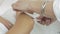 Close up of cosmetologist hands waxing girl hand in beauty saloon. Epilation