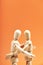 Close-up of a couple of Dummies embracing on an orange background. Love concept