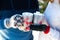 Close-up of a couple holding cups with deers with a hot drink and marshmallows in their hands in warm winter gloves