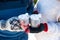 Close-up of a couple holding cups with deers with a hot drink and marshmallows in their hands in warm winter gloves