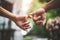 Close up couple holding pinkies fingers  in park in autumn as swear and promise gesture in wedding ceremony. Hands holding of love