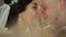 Close-up of a couple of newlyweds with closed eyes gently touching their noses.