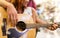 Close up of couple playing guitar over lights