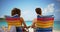 Close-up of couple sitting on beach chairs looking at water horizon.