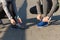 Close up of couple tying shoelaces outdoors