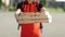 Close-up of the couriers hands and pizza. Portrait of delivery man holding cardboard pizza box against city, courier