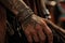 close-up of cowboy& x27;s tattooed hand, with leather and metal accessories visible