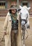 Close up of a Cowboy standing next to his horse