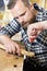 Close-up of craftsman files wooden guitar neck in workshop