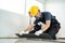 Close-up of Craftsman worker installs laminate board on floor at home. Carpenter worker or Joiner Builder team people wear gloves