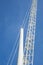 Close up crane and pole of windmill, against blue sky. Space for text.