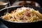 close-up of creamy bowl of spaghetti carbonara, with pepper and cheese visible