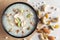 Close-up of Creamy Sabudana Kheer Garnished with dry fruits. Indian delicious dessert. Served in a black bowl. Top View on white