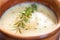 close-up of creamy soup texture with a sprig of thyme on top