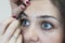 Close-up creating auxiliary lines between the eyebrows to shape the eyebrows.