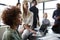 Close up of creative business colleagues listening to an informal presentation in a meeting room