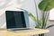 Close up of creative designer office desktop with empty laptop monitor with mock up place in frame, concrete wall background with