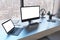 Close up of creative designer table with empty white mock up computer monitor laptop and supplies in modern office with window and