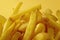 Close Up Of Crispy Golden French Fries On Yellow Background