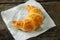 Close up of croissant with white paper on wooden table